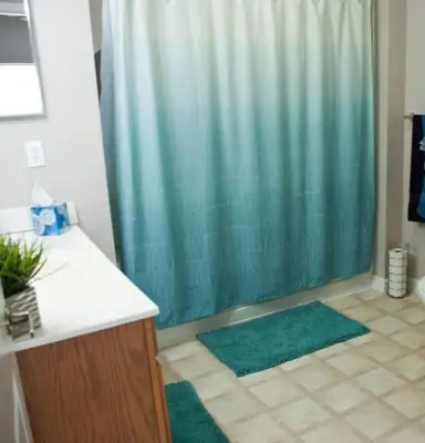 a bathroom with a shower with a green shower curtain at Venetian Bay Townhome townhouse in Kissimmee