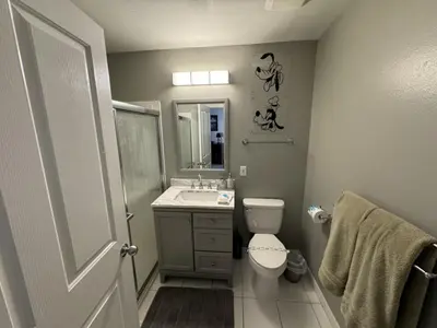 a bathroom with a toilet and a sink and a mirror at Villa Crayson home in Kissimmee