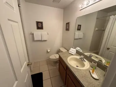 a bathroom with a sink and a toilet and a mirror at Cullen Villa home in Kissimmee