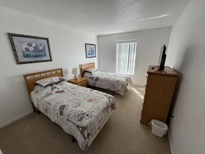 a bedroom with two beds and a television in it at Cullen Villa home in Kissimmee