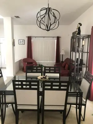 a dining room with a glass table and chairs at Weikva Villa home in Kissimmee