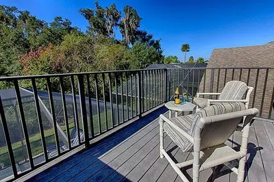 a deck with a chair and a table on a balcony at Weikva Villa home in Kissimmee