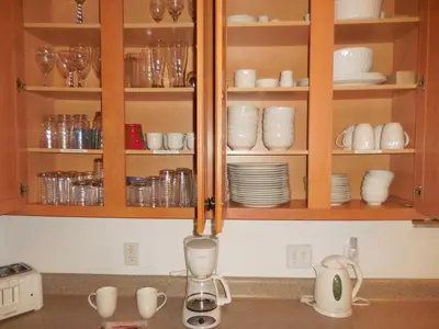 a kitchen counter with cups and dishes in cabinets at Berkeley Pool Home home in Kissimmee