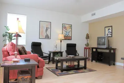 a living room with a red couch and a tv at Berkeley Pool Home home in Kissimmee