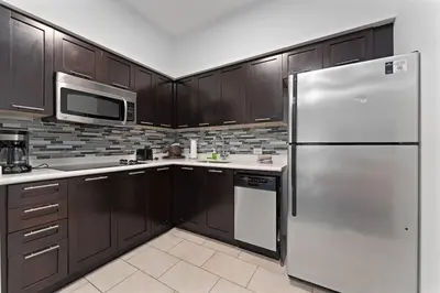 a kitchen with wooden cabinets and a stainless steel refrigerator at Hotel Meliá Orlando in Orlando