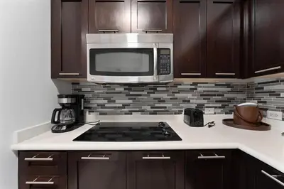 a kitchen with a stove and a microwave at Hotel Meliá Orlando in Orlando