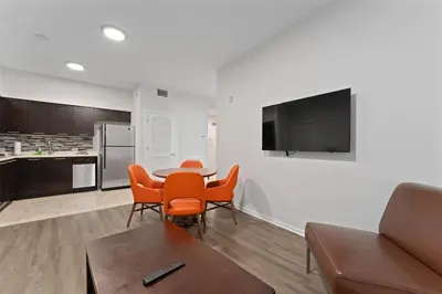 a living room with a table and chairs and a kitchen at Hotel Meliá Orlando in Orlando
