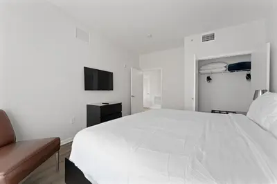 a white bedroom with a large white bed and a chair at Hotel Meliá Orlando in Orlando