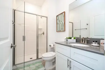 a bathroom with a toilet and a glass shower at Casa 4Q Storey Lake c/ Quarto Temático & Piscina in Kissimmee