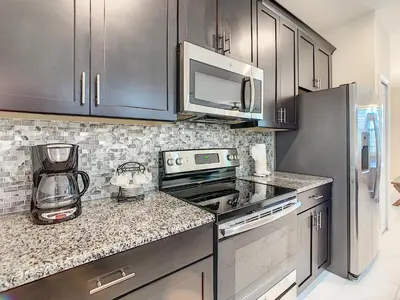 a kitchen with a stove and a microwave at 3065 - 5BR w Pool 10min Disney 2 Water Parks in Kissimmee