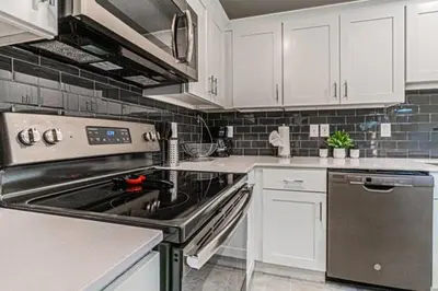 a kitchen with a stove and white cabinets at 3121#308- 3BR Condo 10min Disney 2 WaterParks in Kissimmee