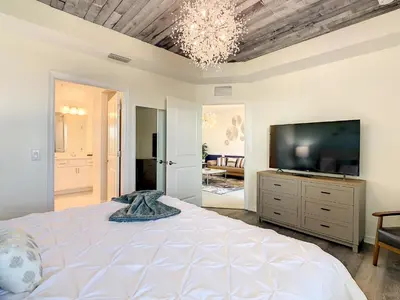 a bedroom with a large bed and a flat screen tv at 4731#201- 3BR Condo 10min Disney 2 WaterParks in Kissimmee