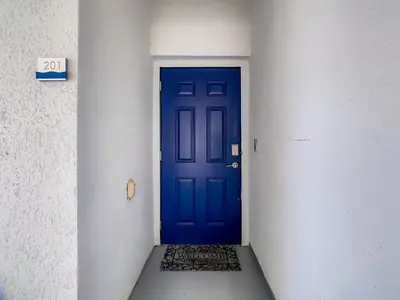 a blue door in a white hallway with a ramp at 4731#201- 3BR Condo 10min Disney 2 WaterParks in Kissimmee