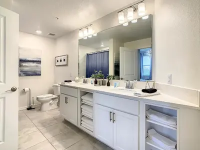 a bathroom with two sinks and a large mirror at 4731#201- 3BR Condo 10min Disney 2 WaterParks in Kissimmee