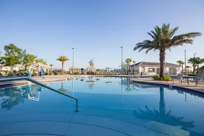 a large swimming pool with palm trees in a resort at 4731#208- 3BR Condo 10min Disney 2 WaterParks in Kissimmee