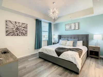 a bedroom with a bed and a chandelier at 4731#301- 3BR Condo 10min Disney 2 WaterParks in Kissimmee