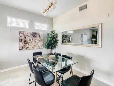 a dining room with a glass table and chairs at 4731#308- 3BR Condo 10min Disney 2 WaterParks in Kissimmee