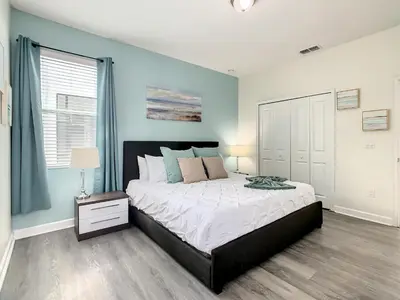 a bedroom with a large bed with blue walls at 4766 - 5BR w Pool 10min Disney 2 Water Parks in Kissimmee