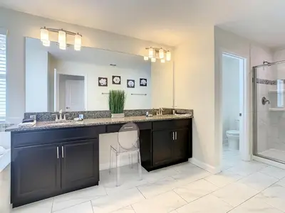 a bathroom with a black vanity and a mirror at 4766 - 5BR w Pool 10min Disney 2 Water Parks in Kissimmee
