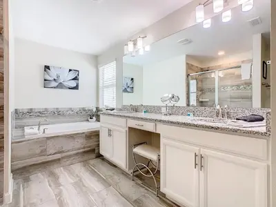 a white bathroom with two sinks and a tub and a mirror at 4774 - 7BR w Pool 10min Disney 2 Water Parks in Kissimmee
