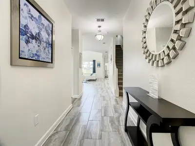 a hallway with a table and a mirror at 4781 - 5BR w Pool 10min Disney 2 Water Parks in Kissimmee