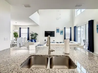 a kitchen with a sink and a living room at 4781 - 5BR w Pool 10min Disney 2 Water Parks in Kissimmee
