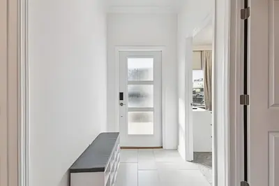 a white hallway with a black bench and a door at Luxo Storey Lake | 5Q Piscina Aquecida & Resort in Kissimmee