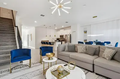 a living room with a couch and blue chairs at Luxo Storey Lake | 5Q Piscina Aquecida & Resort in Kissimmee