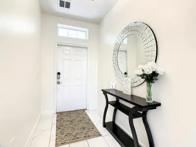 a hallway with a black table and a mirror at 4809 - 5BR w Pool 10min Disney 2 Water Parks in Kissimmee