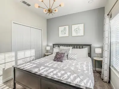 a bedroom with a large bed and two tables at 4916 - 5BR w Pool 10min Disney 2 Water Parks in Kissimmee