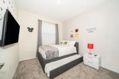 a small bedroom with a bed and a tv at Lake View Condo Near Disney in Kissimmee