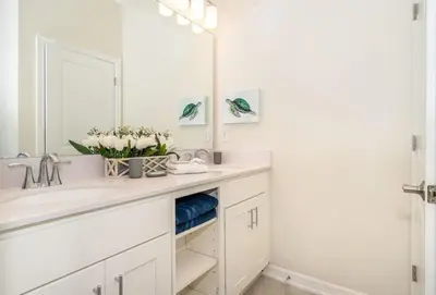a white bathroom with a sink and a mirror at Lake View Condo Near Disney in Kissimmee