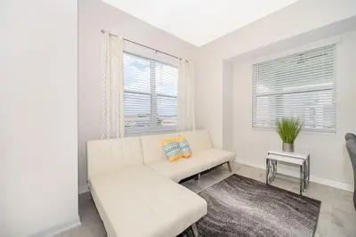 a white living room with a couch and a table at Lake View Condo Near Disney in Kissimmee