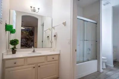 a bathroom with a sink and a shower with a mirror at Veranda Palms 6BR Pool Near Disney Parks in Kissimmee