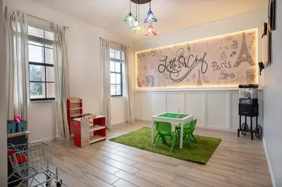 a living room with a green table and a wall with graffiti at Veranda Palms 6BR Pool Near Disney Parks in Kissimmee