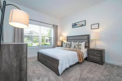 a bedroom with a large bed and a window at 4BR Pool Home at Storey Lake Near Disney in Kissimmee