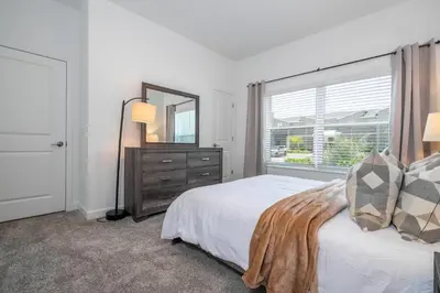 a bedroom with a bed and a dresser and a window at 4BR Pool Home at Storey Lake Near Disney in Kissimmee