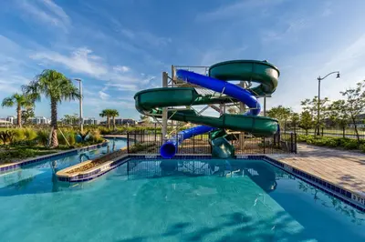 a water slide in a pool at a resort at 4BR Pool Home at Storey Lake Near Disney in Kissimmee