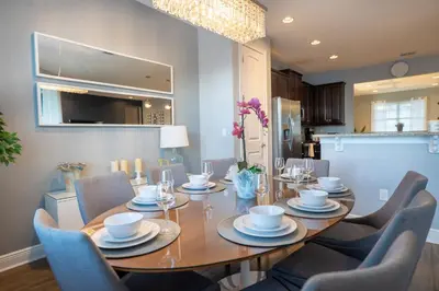 a dining room with a wooden table and chairs at 6BR Home w Theater Pool Near Disney in Orlando