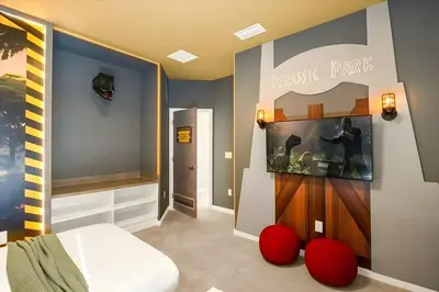 a bedroom with a bed and red ottomans at Luxury 12BR Home w Pool Game Room in Orlando