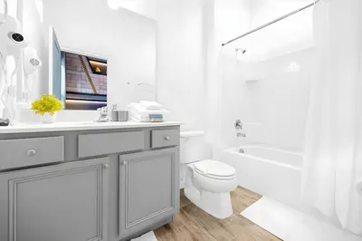 a white bathroom with a sink and a toilet at Luxury 12BR Home w Pool Game Room in Orlando