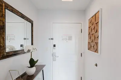 a white hallway with a mirror and a table at Cozy Apartment at The Point in Orlando