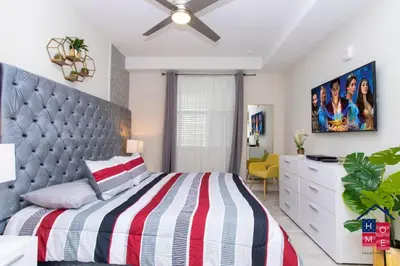 a bedroom with a large bed and a dresser at Vibrant Family Condo -10 Min From Disney in Kissimmee