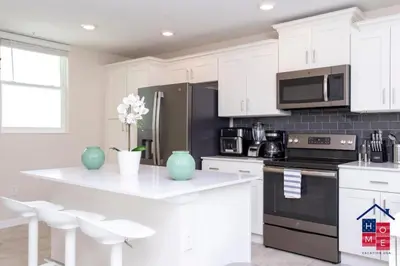a kitchen with white cabinets and a black refrigerator at Condo near Disney with Resort in Kissimmee