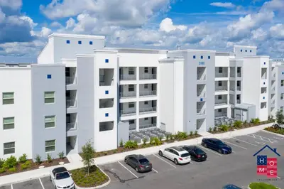 an apartment building with cars parked in a parking lot at Condo near Disney with Resort in Kissimmee