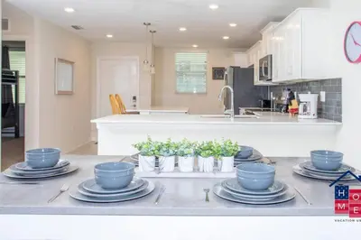 a kitchen with blue dishes and plants on a counter at Stunning Condo in the Heart of Orlando in Kissimmee