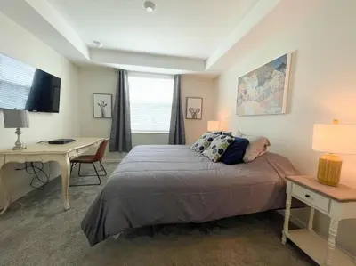 a bedroom with a bed and a desk and a desk at Stunning Condo in the Heart of Orlando in Kissimmee