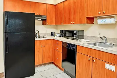 a kitchen with a black refrigerator and a sink at 2 Queen Beds Condo Near Universal Studios With Pool & Hot Tub in Orlando