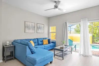 a blue couch and chair in a living room at Elegant Townhome with Water View in Kissimmee