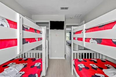 a bedroom with two bunk beds and a tv at Elegant Townhome with Water View in Kissimmee